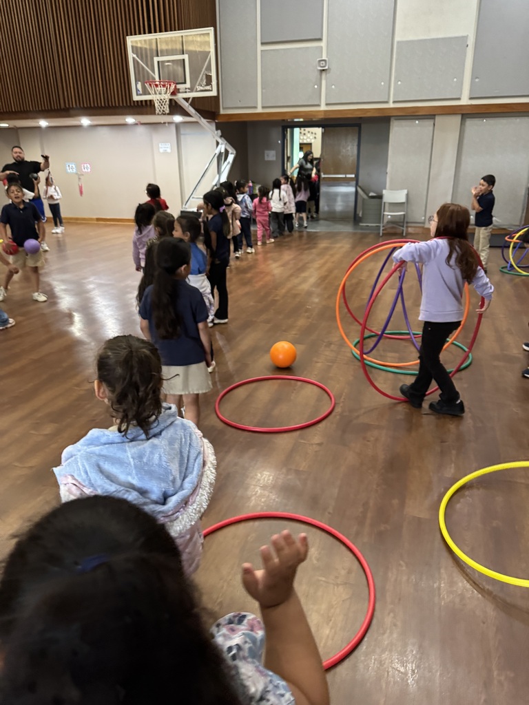 Students playing in the gym with hoola hoops