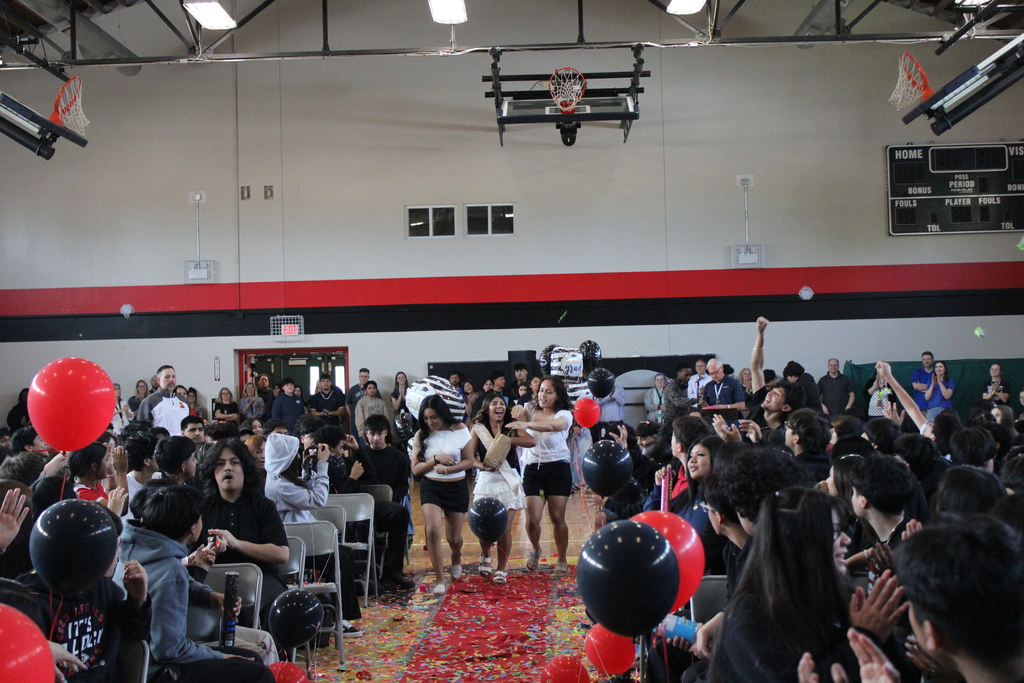 student walking and students cheering  