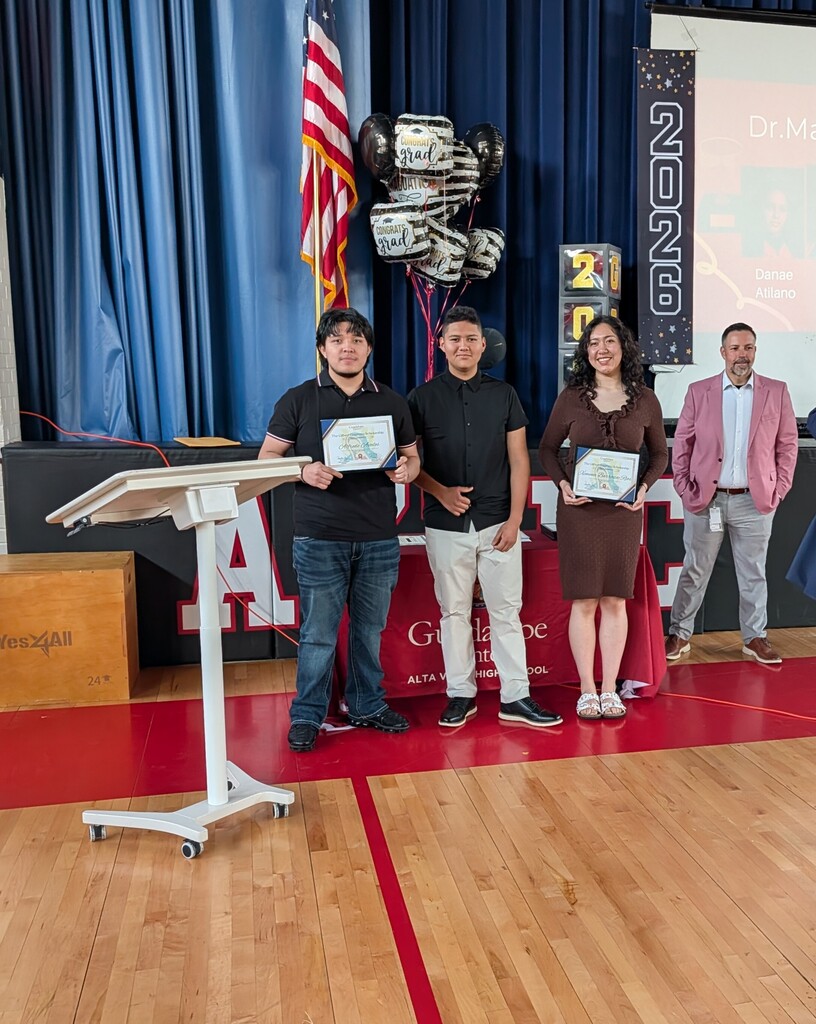 student standing in front of a screen with awards
