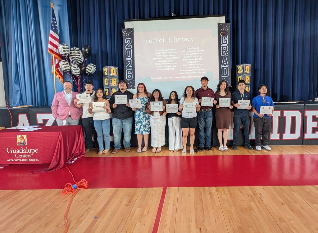 student standing in front of a screen with awards