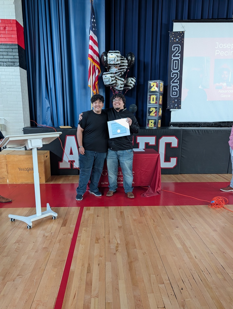 student standing in front of a screen with award