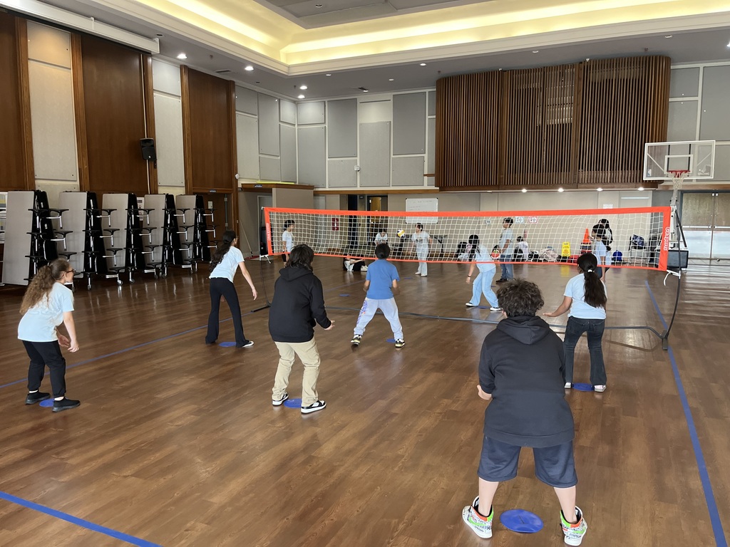 Students playing volleyball one is serving