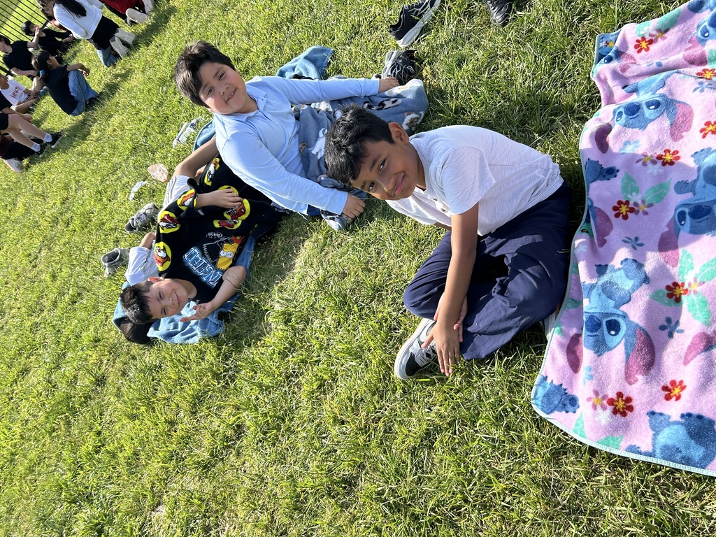 students sitting on the grass looking at the camera