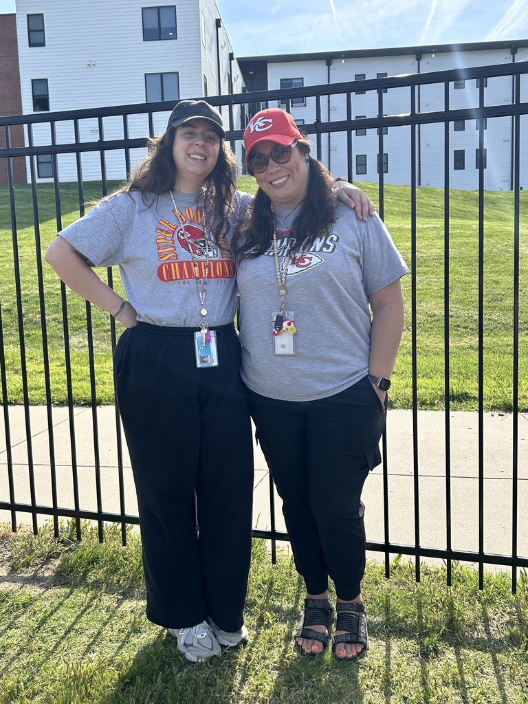 Two females standing wearing a cap posing for a picture