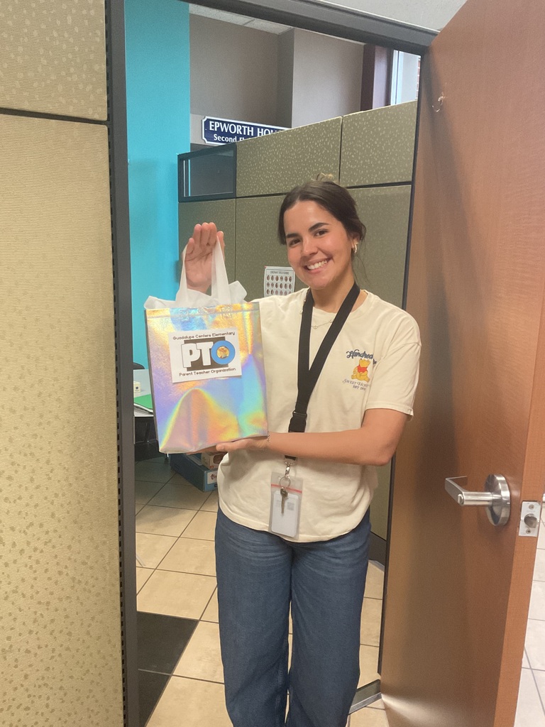 A woman holding a gift bag by a door