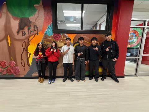 a group of students in front of a murual