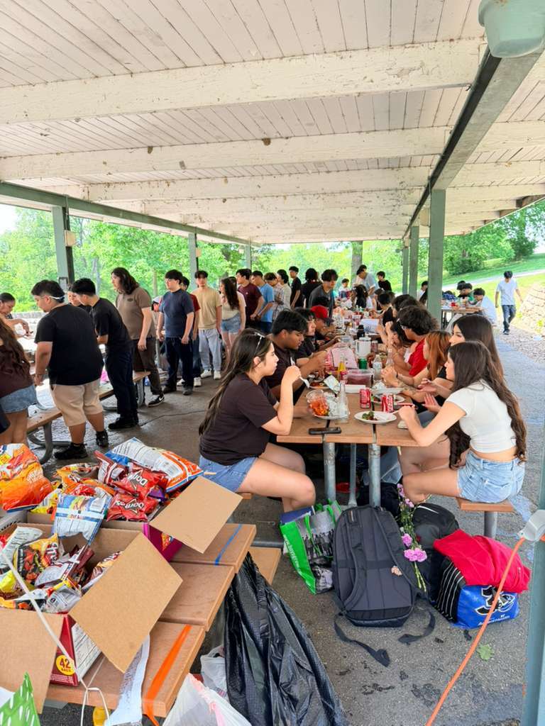 Students sitting on a table eating and lined up