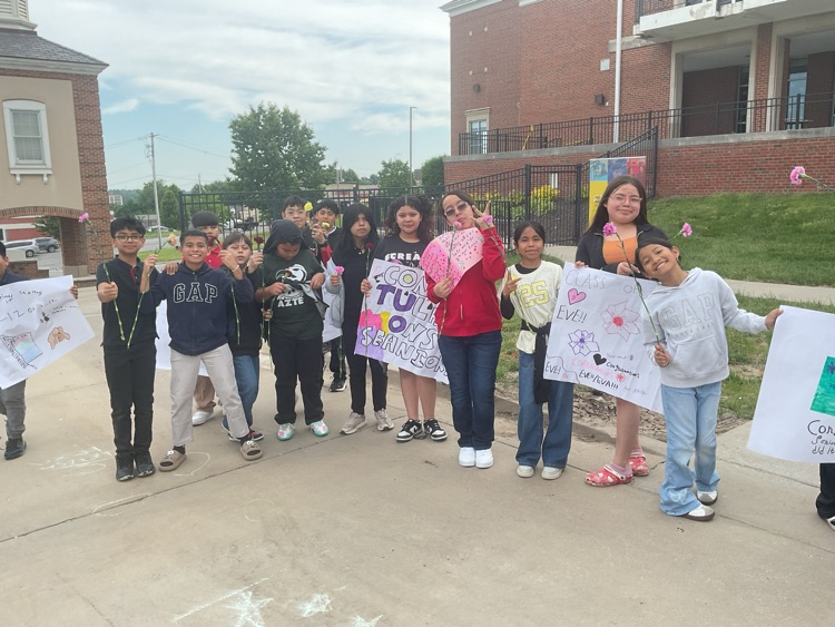 students next to each other holding signs outdoor