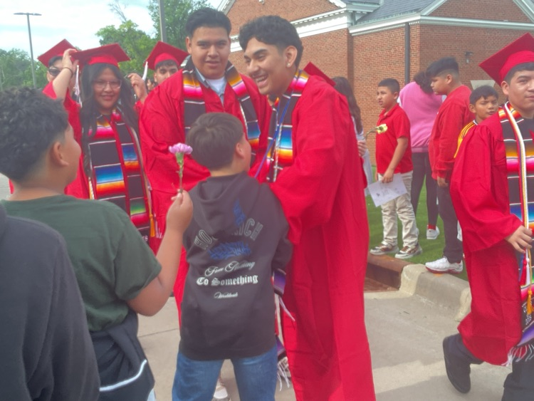 students receiving a flowers from younger students