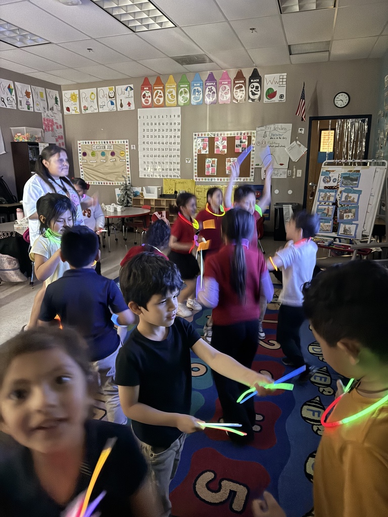 kids standing while watching a movie and playing with glow sticks