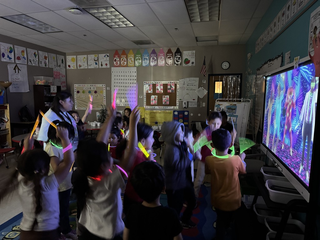 kids standing while watching a movie and playing with glow sticks