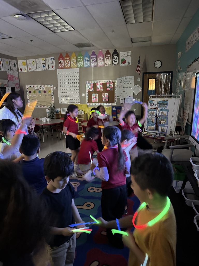 kids standing while watching a movie and playing with glow sticks