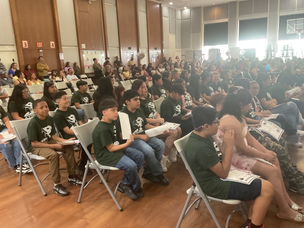 rows of students and adults sitting on chairs