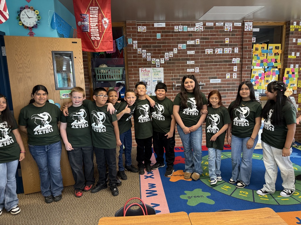 A group of students standing in a classroom posing for a picture