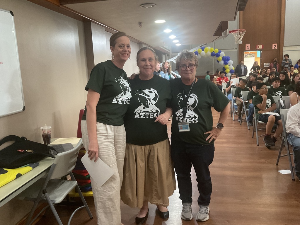 3 women wearing the same shirt posing for the camera