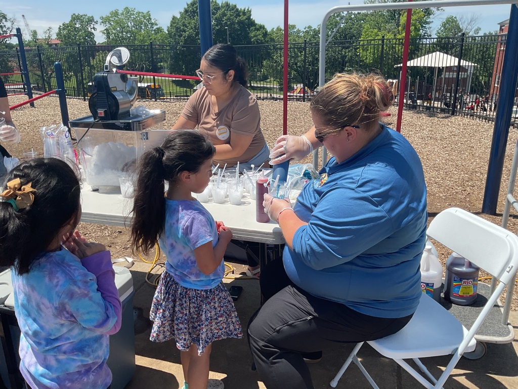 2 adults preparing snow cones and 2 kids waiting
