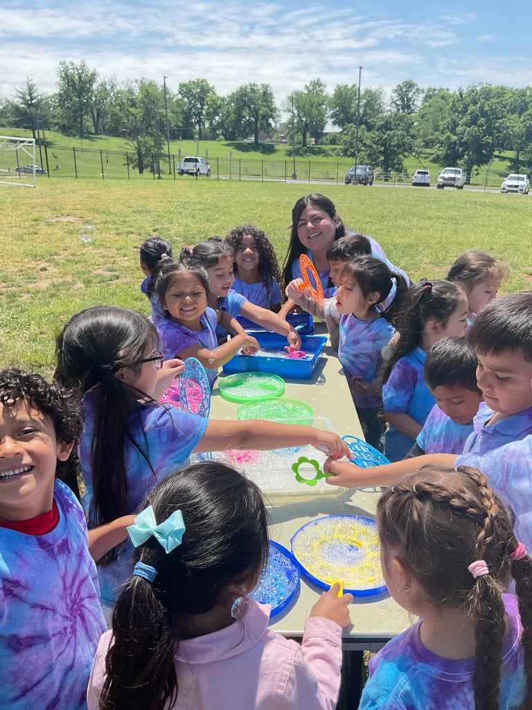 A group of students standing around a table playing with bubbles