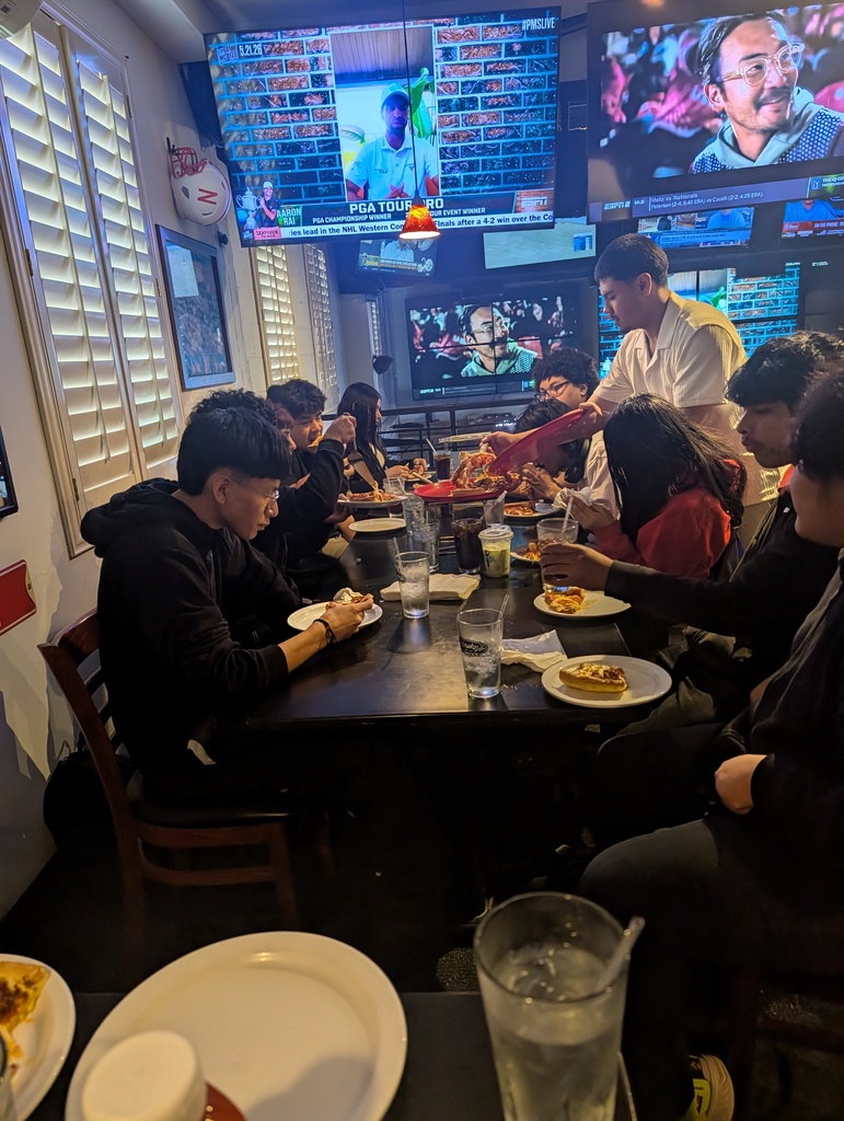 a group of students eating pizza
