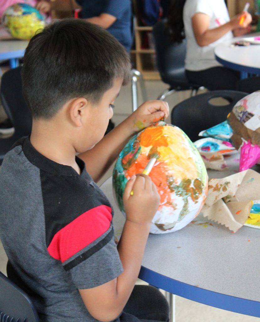 prek student painting a pinata