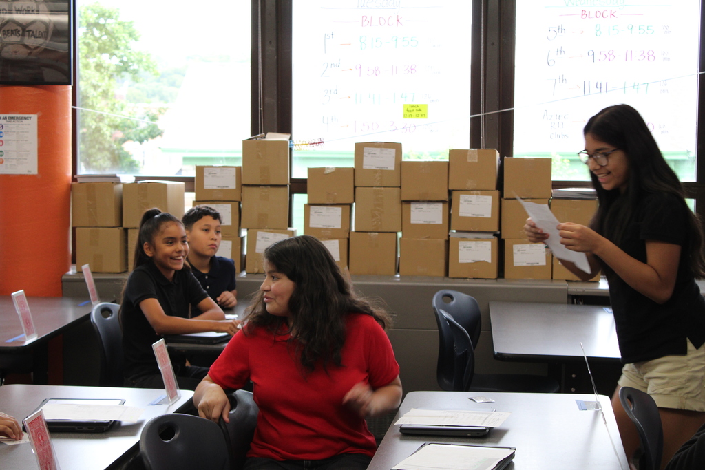 students introducing each other and a student standing up speaking to her classmates