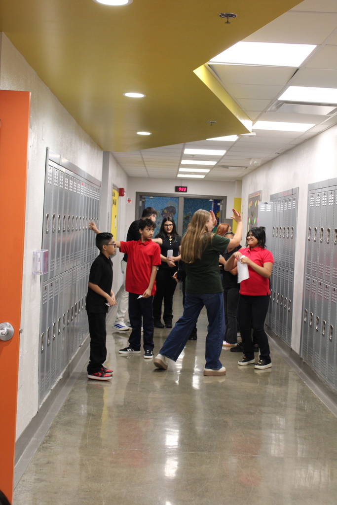 students learning how to open up their locker and teacher giving a student a high five