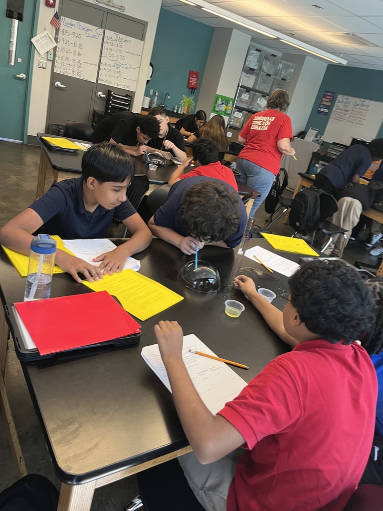 students are working together as a team on the black table to make a big bubble