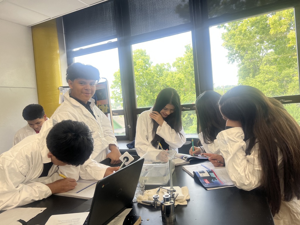 students wearing their white lab coat and working as a team 