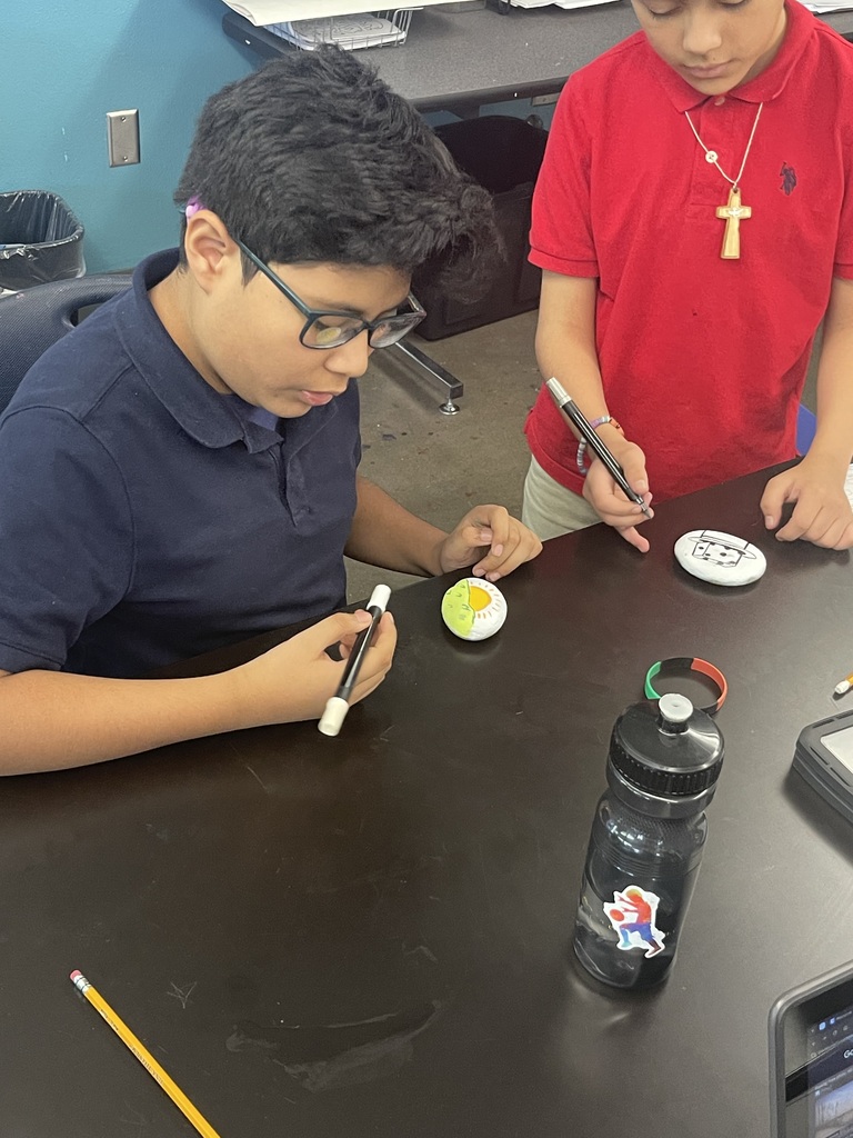 student in glasses painting his rocks