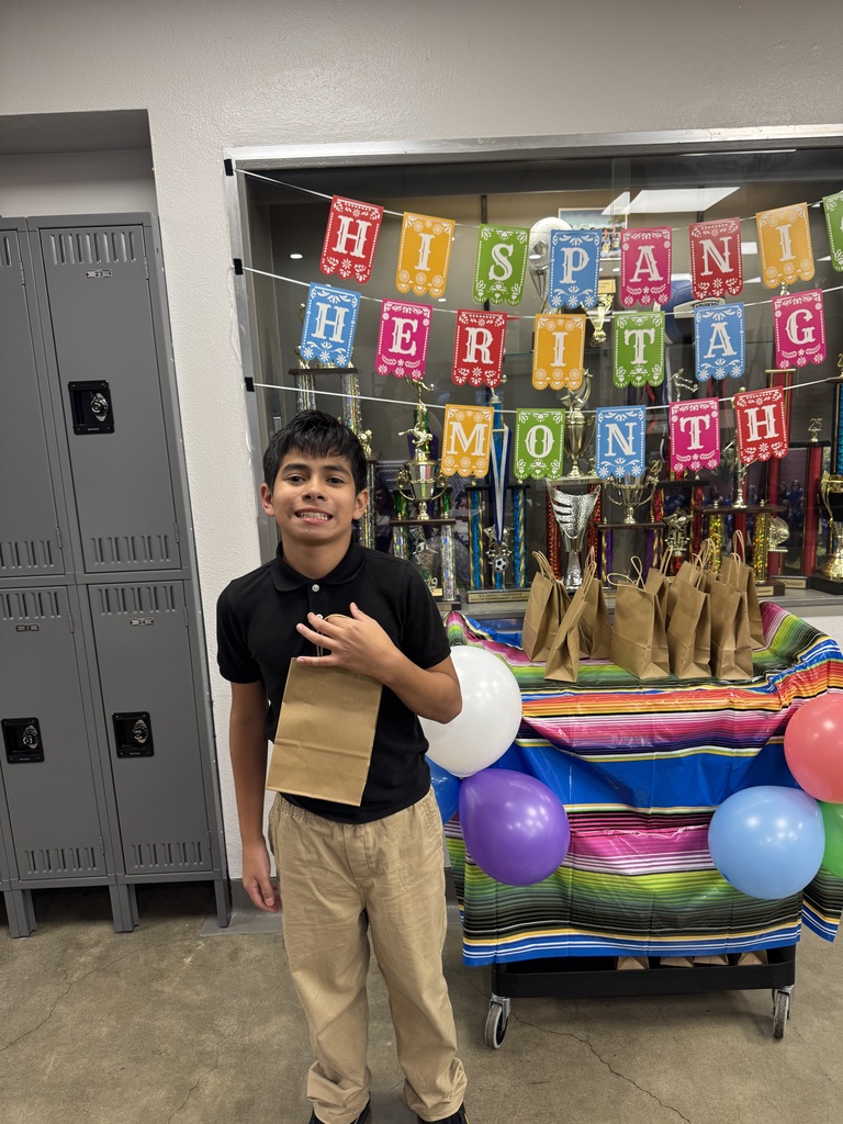 student in blue holding up his goodie bag
