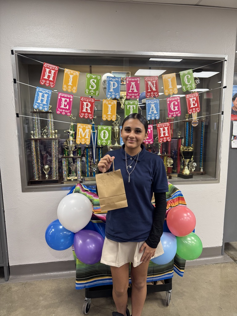 student is blue holding up their goodie bag