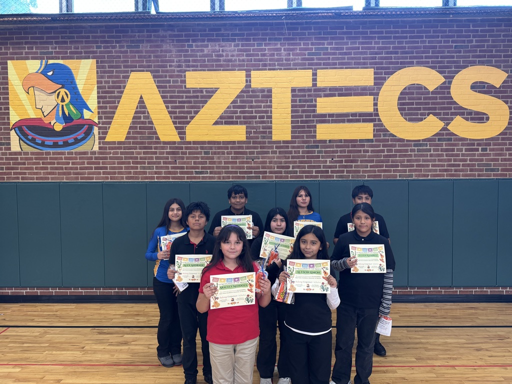Students posting in front of the Aztecs sign at our gym