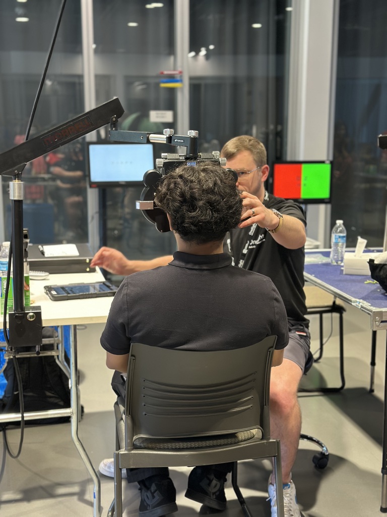 student wearing a black polo shirt getting his vision checked