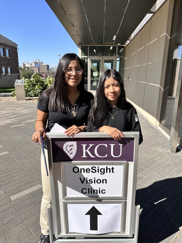 iris and blanca posing for a picture behind the onesight sign