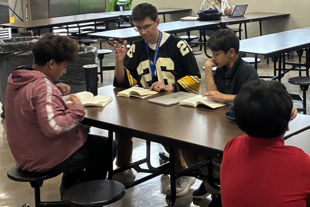 Mr. Leavens and Giovanni are focused on their reading, sharing a quiet moment as they dive into a book together.