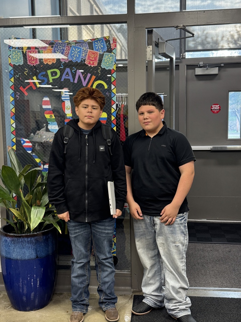 two students wearing black shirts and jeans, posing for a picture