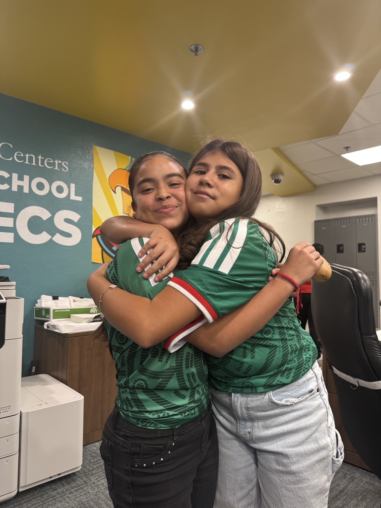 two friends hugging each other wearing a green jersey