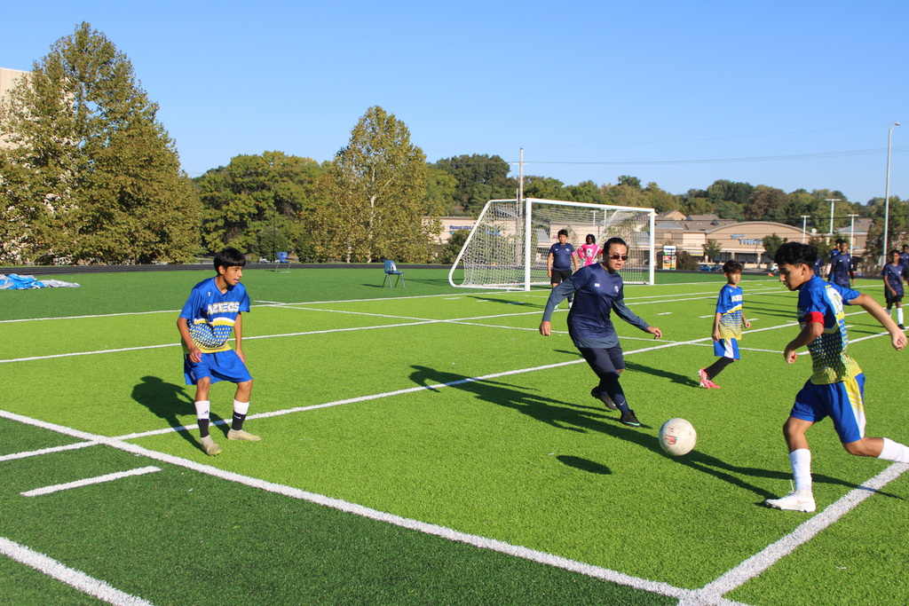boys playing soccer on a very green field