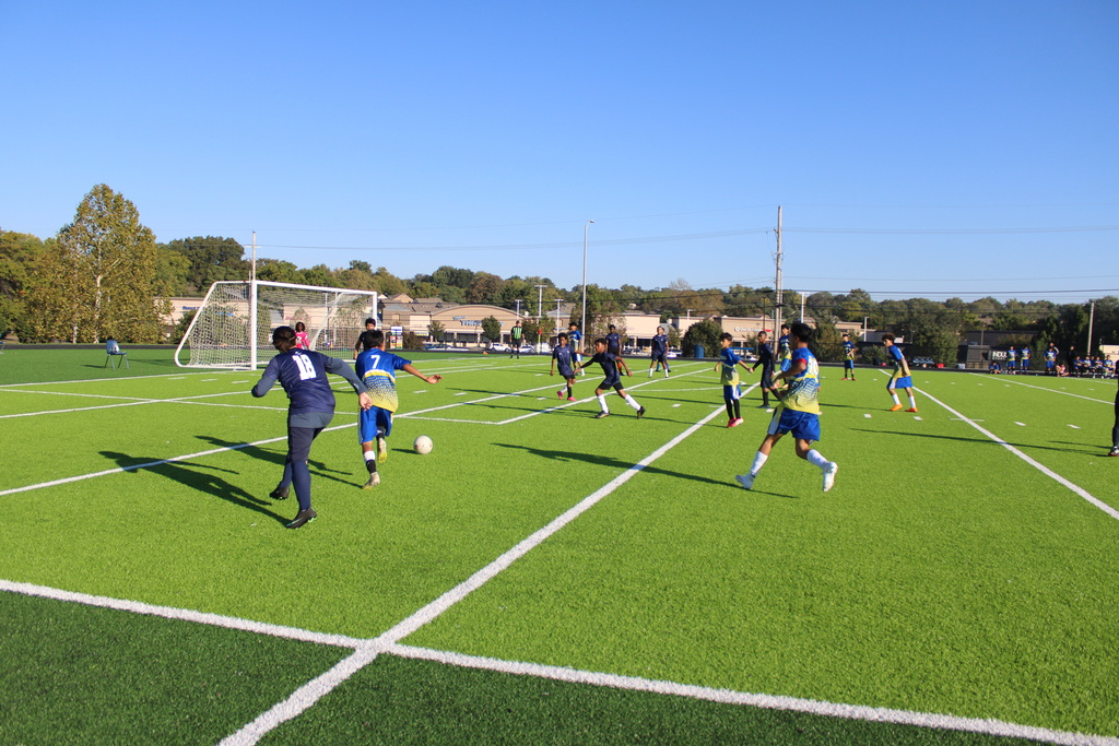 boys playing soccer on a very green field