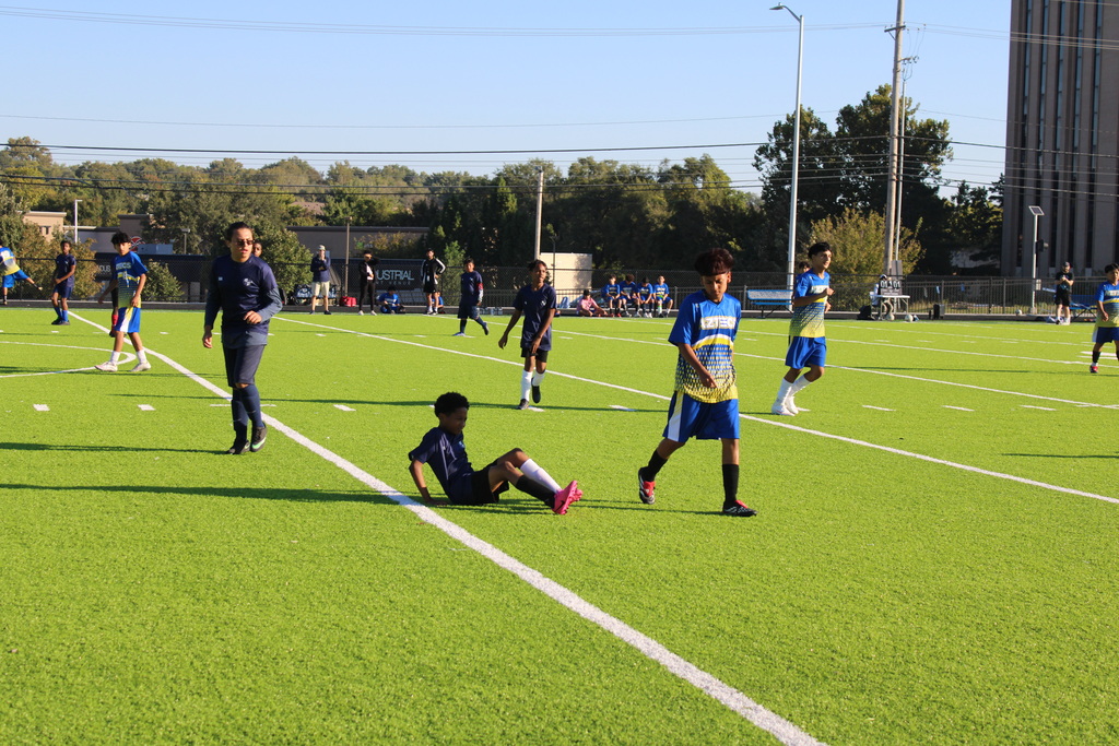 boys playing soccer on a very green field
