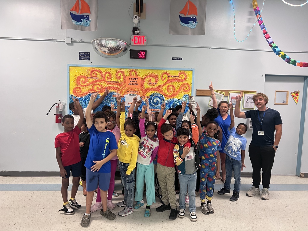 Ms. Miller's 2nd grade class holding up a number "1" with their fingers in front of the bulletin board declaring them the winners!