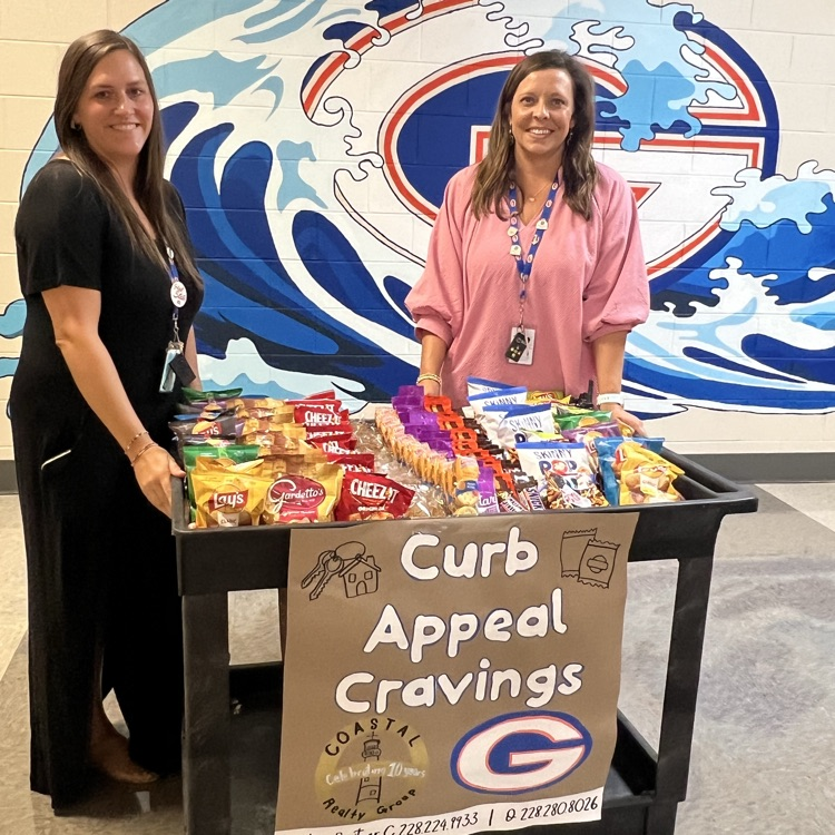 GHS administrators are posing with the Curb Appeal Cravings snack cart for teachers provided by Timothy Switzer with Coastal Realty group. 
