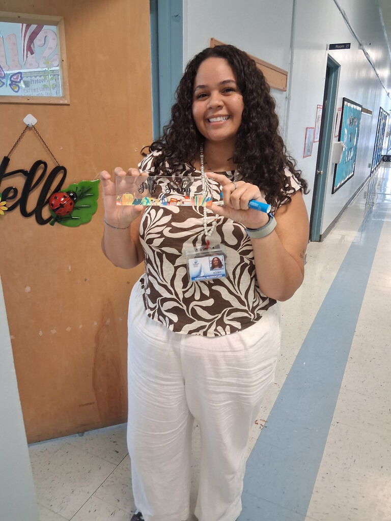 Ms. Scoby, a 2nd grade teacher, holding a custom piece from Covenant Christian Bookstore