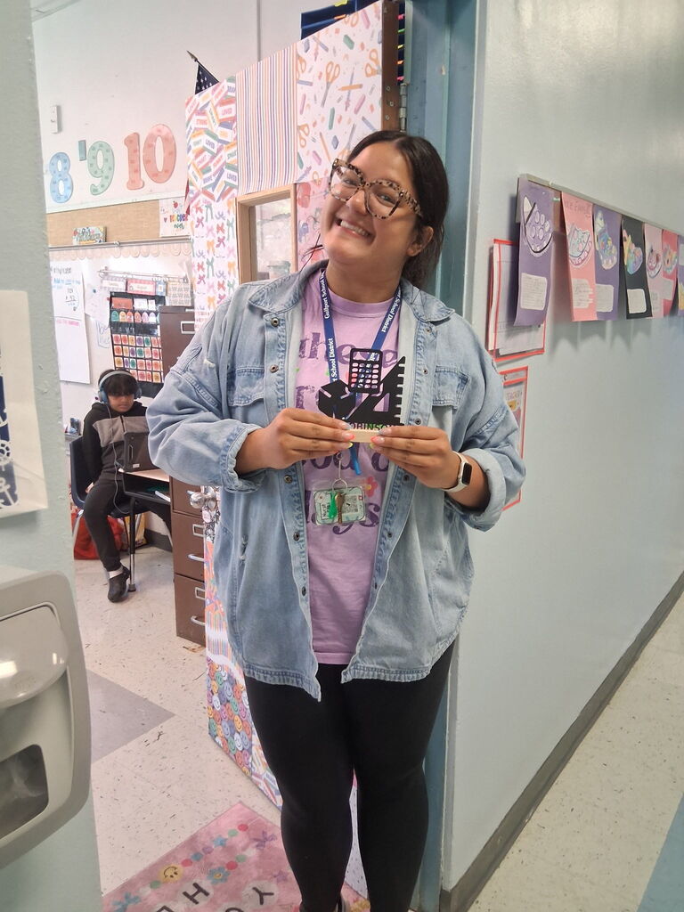 Ms. Robinson, a 5th grade teacher, holding a custom piece from Covenant Christian Bookstore