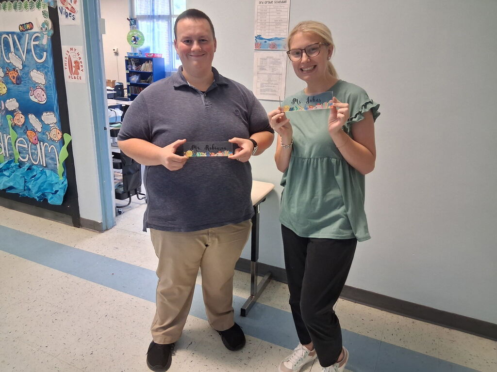 Mr. Robinson and Ms. Johns, 3rd grade teachers, holding custom pieces from Covenant Christian Bookstore