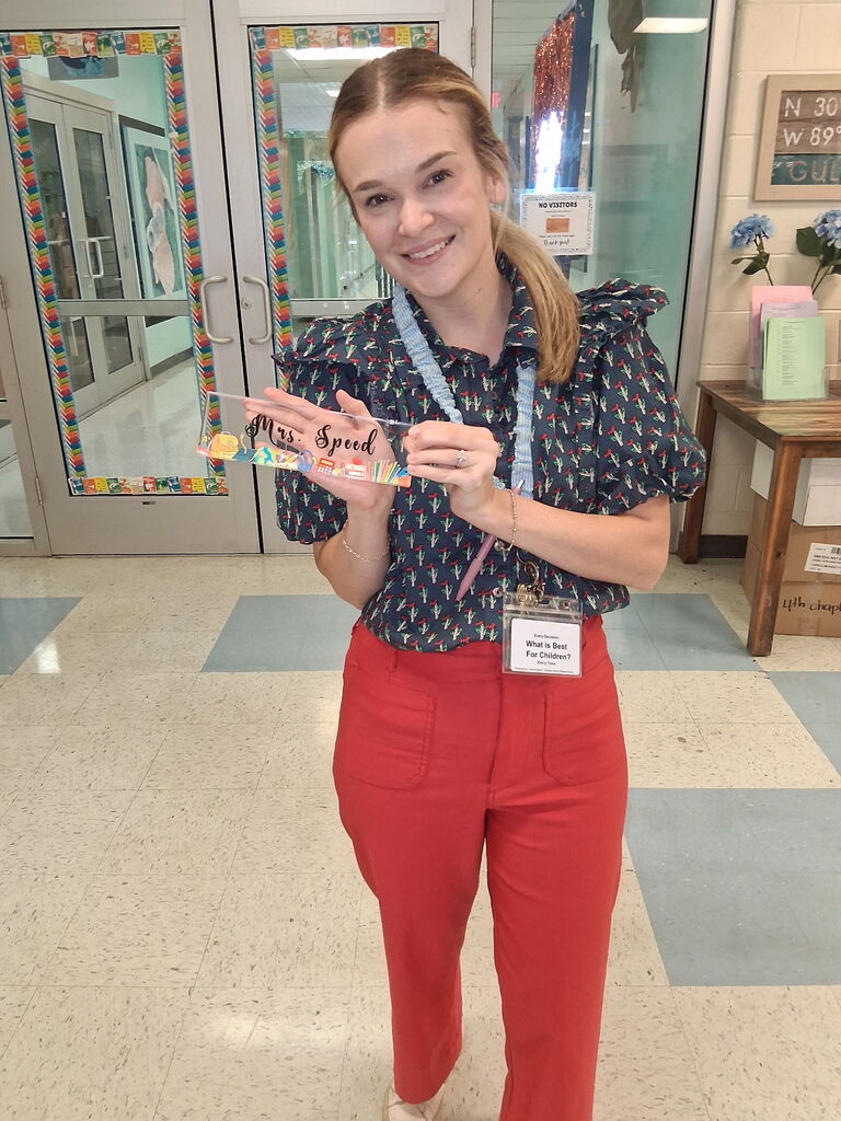 Ms. Speed, a Kindergarten teacher, holding a custom piece from Covenant Christian Bookstore