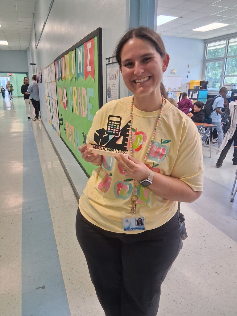 Ms. DeFrances, a 4th grade teacher, holding a custom piece from Covenant Christian Bookstore