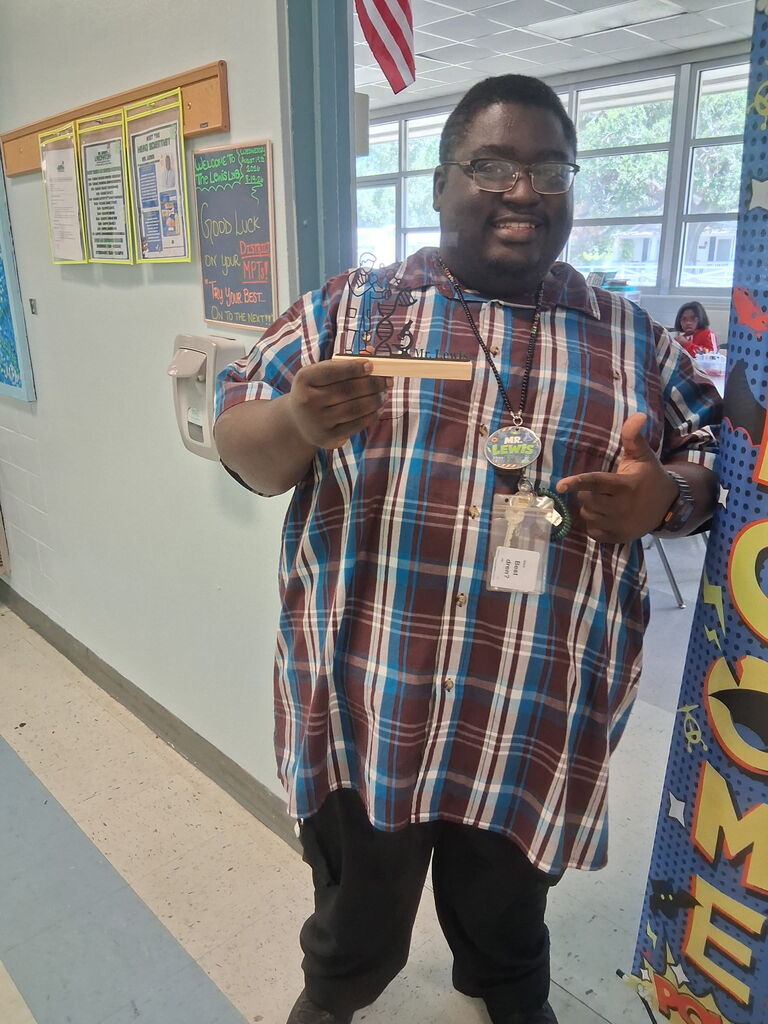 Mr. Lewis, a 4th grade teacher, holding a custom piece from Covenant Christian Bookstore