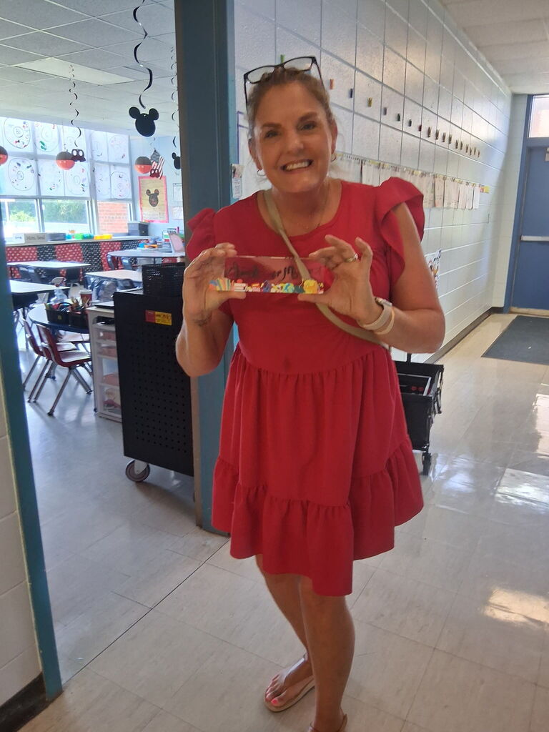 Mrs. Seal, a Kindergarten teacher, holding a custom piece from Covenant Christian Bookstore