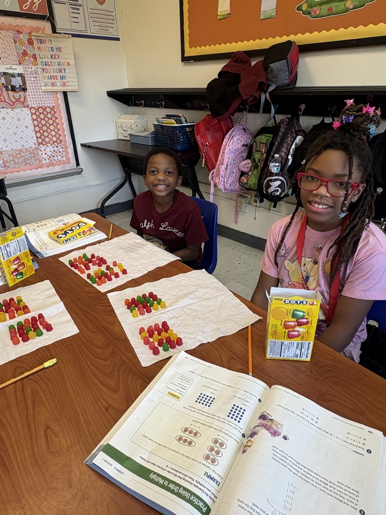 Two students showing their arrays they built with Dots candy