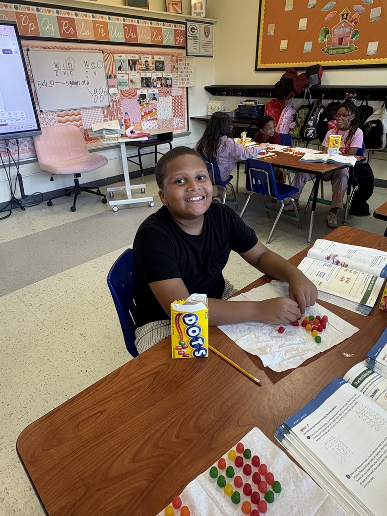 A student showing his array he built with Dots candy